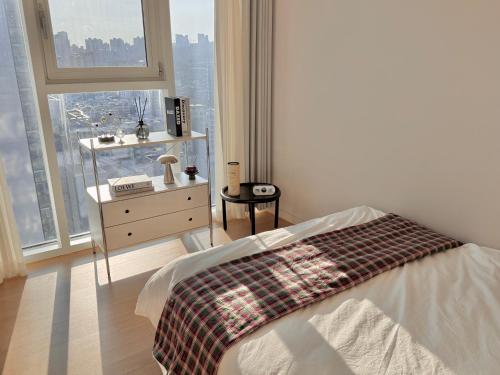 a bedroom with a bed and a dresser and a window at Azur Stay in Kwangan-dong