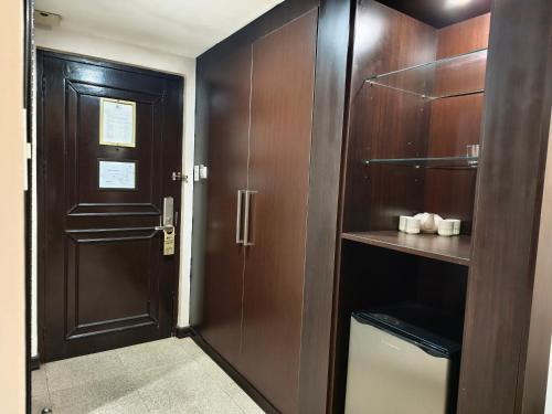 a bathroom with wooden cabinets and a door at Lido De Paris Hotel in Manila