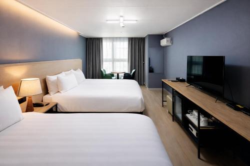 a hotel room with two beds and a flat screen tv at Hotel Bernoui Seoul in Seoul