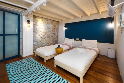 a room with two beds and a blue wall at Non Inn The Diamond Artisan and Barber 4 Bedroom Riverside Retreat with King and Twin Rooms in Bang Rak