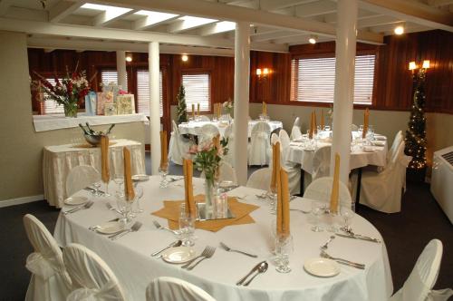 a dining room with white tables and white chairs at Delta King Hotel in Sacramento