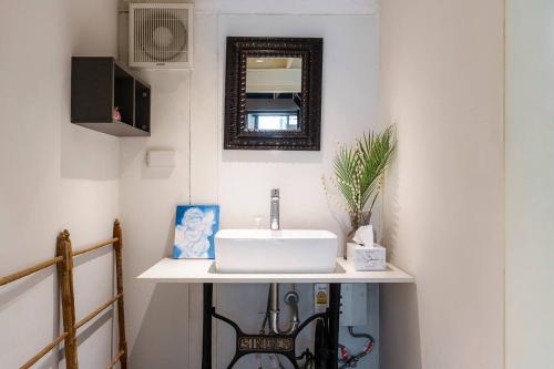 a bathroom with a white sink and a mirror at Non Inn The Diamond Artisan and Barber 4 Bedroom Riverside Retreat with King and Twin Rooms in Bang Rak