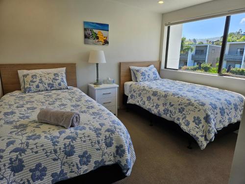 a bedroom with two beds and a window at Aqua Soleil Beachfront Apartment in Whitianga