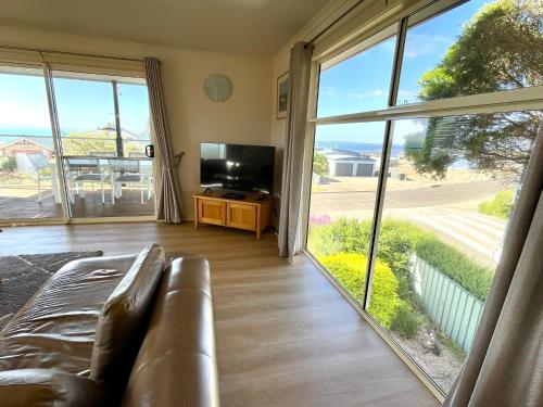 a living room with a couch and a large window at Bayview Beach House Apartment No 2 in Kingscote