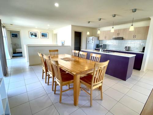 a kitchen and dining room with a wooden table and chairs at Bayview Beach House Apartment No 2 in Kingscote