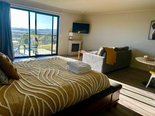 a bedroom with a large bed and a living room at The Top Place Retreat in Caveside