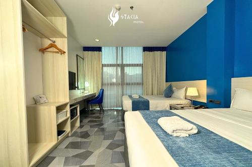 a hotel room with two beds and a television at Stacia Hotel in Cebu City