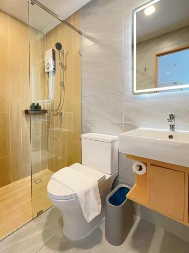 a bathroom with a toilet and a sink and a shower at Wynora Hotel in Klong Toi
