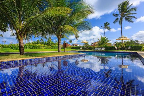 a swimming pool with palm trees in a resort at Vivá Porto de Galinhas Resort in Porto De Galinhas