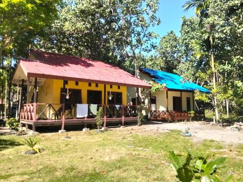 a small yellow house with a red roof at Papua Risen Beach Front Bungallow in Insyurifuri