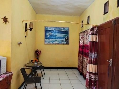a room with a table and a table and chairs at Papua Risen Beach Front Bungallow in Insyurifuri