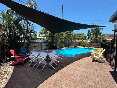 a group of chairs and a table next to a pool at Shakespeare Motel in Mackay