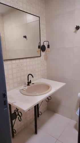 a white bathroom with a sink and a mirror at Hotel Lagoa in Laguna