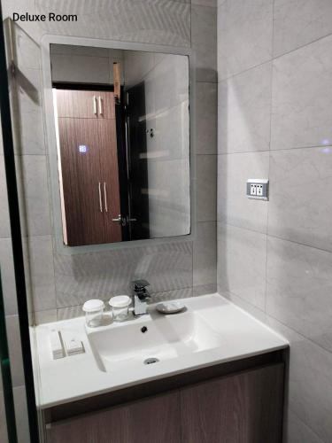 a bathroom with a sink and a mirror at RAI ATRIUM SUITES HOTEL - Cauayan in Cauayan City