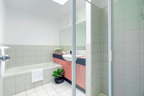a bathroom with a sink and a bath tub at ParkView on Owen in Huskisson
