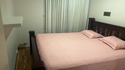 a bedroom with a bed with pink pillows on it at Comfort Home For You 203 in Perth