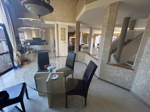 a dining room with a glass table and chairs at Comfort Home For You 203 in Perth
