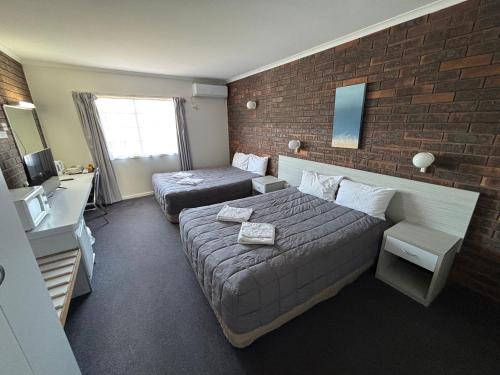 a hotel room with a bed and a couch at Shakespeare Motel in Mackay