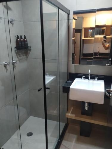 a bathroom with a sink and a glass shower at Sky Design Alphaville Hotel Residence in Barueri