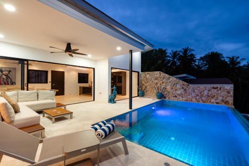 a villa with a swimming pool and a living room at Savaya Samui Villa in Ban Ko Khwan