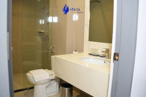 a bathroom with a toilet and a sink and a shower at Stacia Hotel in Cebu City
