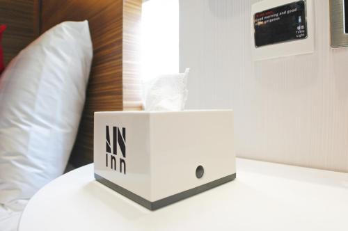 una caja blanca encima de una cama en In Inn, en Hong Kong
