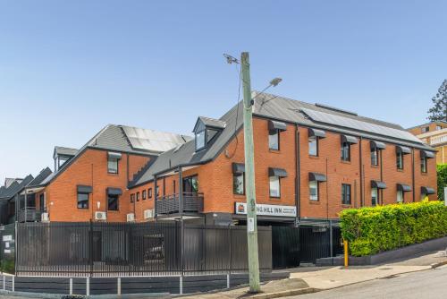 a large red brick building on a city street at Spring Hill Inn in Brisbane
