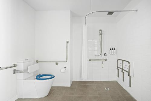 a white bathroom with a toilet and a shower at Quest Townsville on Eyre in Townsville