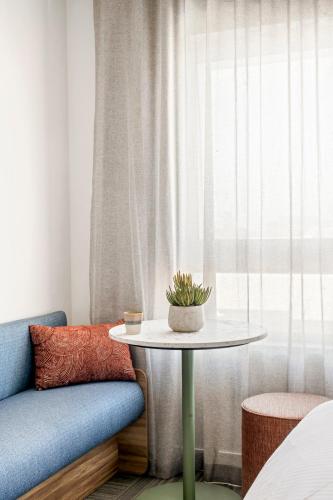 a table with a plant on it next to a window at Quest Townsville on Eyre in Townsville
