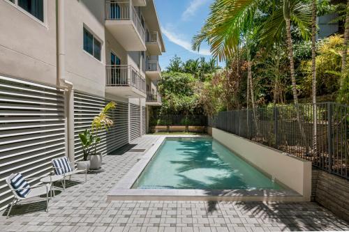 a swimming pool in the courtyard of a building at Quest Townsville on Eyre in Townsville