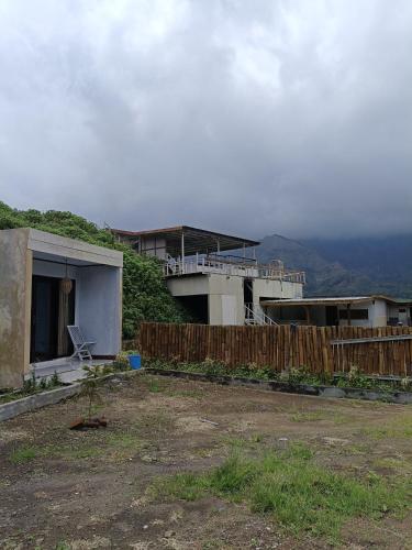a house with a fence in a yard at Queen Rinjani Stay & Café in Sembalun Lawang