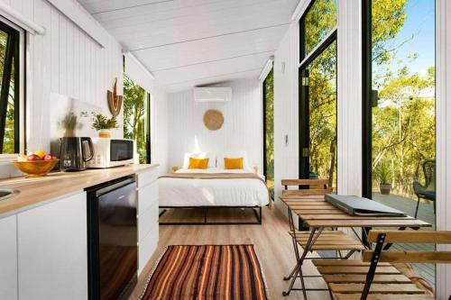 a bedroom with a bed and a kitchen with a table at HeartStone Hill by Tiny Away in Castlemaine