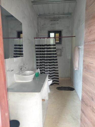 a white bathroom with a sink and a shower at Sansalo Lounge Capira in Lídice