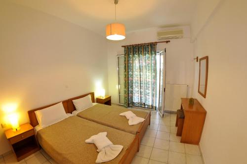 a bedroom with a bed with two towels on it at Egli Apartments in Kontokali