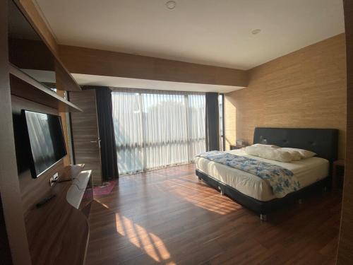 a bedroom with a bed and a large window at Green Minimalist in Jakarta