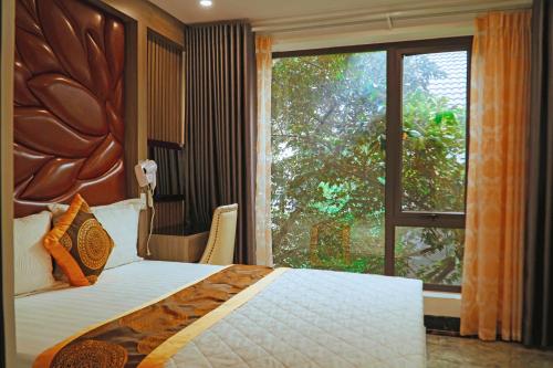 a bedroom with a bed and a large window at Queen Hotel Van Phu Urban in Hà Ðông