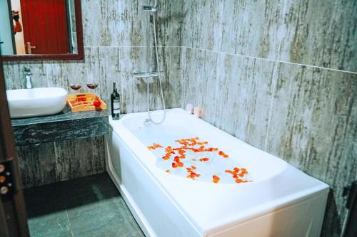 a bathroom with a bath tub with orange flowers on it at Queen Hotel Van Phu Urban in Hà Ðông