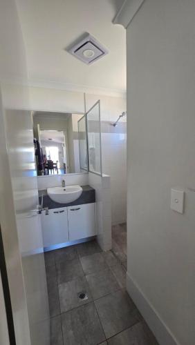 a white bathroom with a sink and a mirror at Four Seasons Holiday Park in Marybrook
