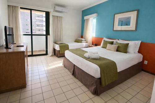 a hotel room with a large bed and a television at Caesar Towers Hotel by Asas Tur in Recife