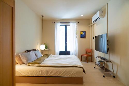 a bedroom with a bed and a flat screen tv at Oceanchild Khaolak in Khao Lak