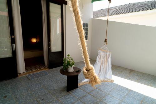 a rope swing with a potted plant on a porch at Oceanchild Khaolak in Khao Lak