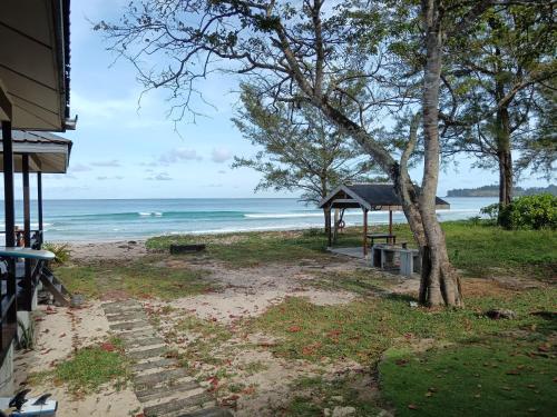 a beach with a gazebo and the ocean at Kudat Beach House 4 in Kudat