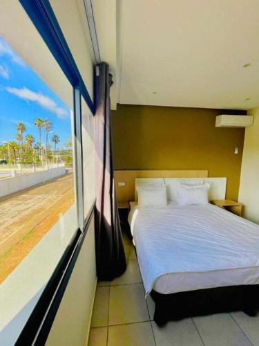 a bedroom with a bed and a window at Appart Hôtel Pyramides El Jadida in El Jadida