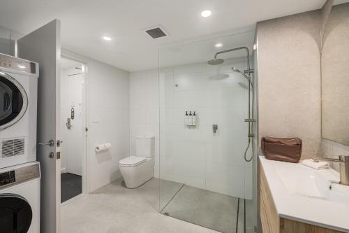 a bathroom with a shower and a toilet and a sink at Quest Newcastle in Newcastle