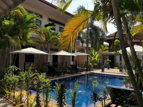 una piscina di fronte a un edificio con ombrelloni di Amara Angkor Boutique a Phumĭ Réach Born