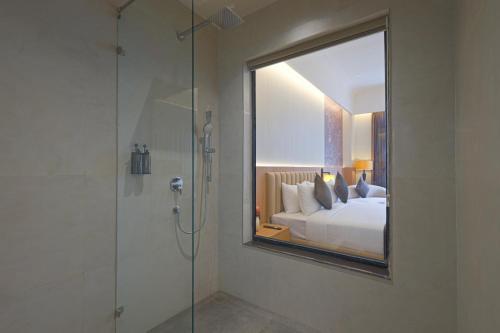 a bedroom with a mirror and a bed and a shower at Sterling Avante Chandigarh Mohali in Mohali