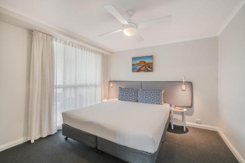 a bedroom with a white bed and a window at Quest Newcastle in Newcastle