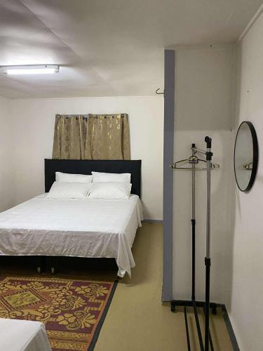 una camera da letto con un letto bianco e uno specchio di Avondale Place a Nuku‘alofa