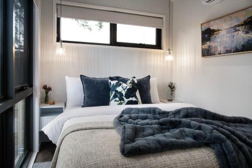 ein Schlafzimmer mit einem großen Bett und einer Decke in der Unterkunft Piccola Blu Tiny House in Hepburn