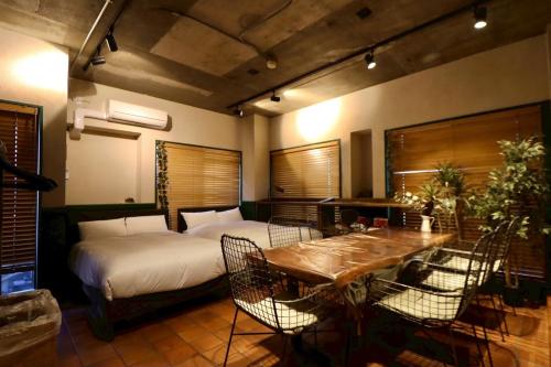 a bedroom with a bed and a table and chairs at サンモール第三マンション in Tokyo